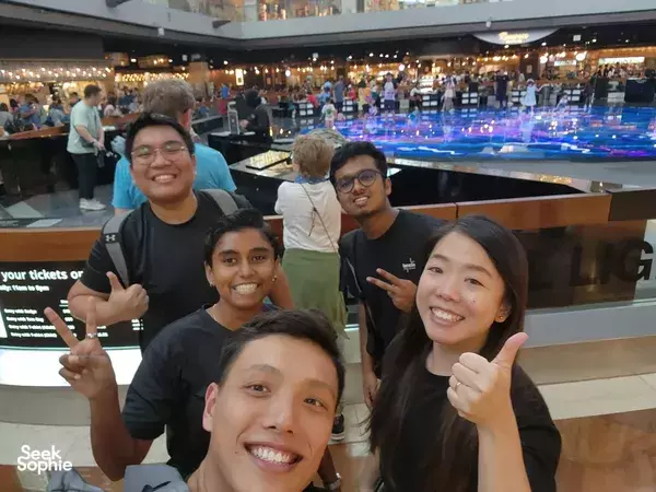 Team posing and smiling with peace signs at a venue in Marina Central, Singapore for a wealth-themed challenge — team building Singapore