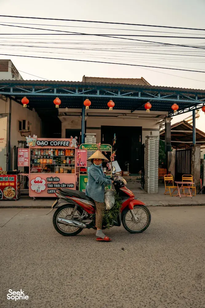 Pengendara motor menunggu di luar kedai kopi Vietnam di Hoi An, diabadikan saat singgah di jalan dalam tur berpemandu