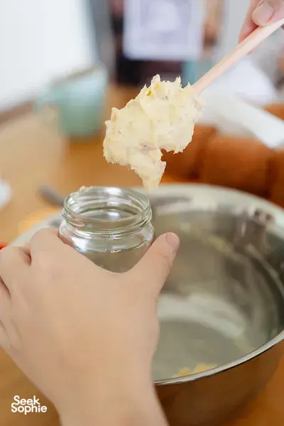 Hands lifting fluffy shio pan and spreading flavoured butter during a bread-making class—workshops in Singapore
