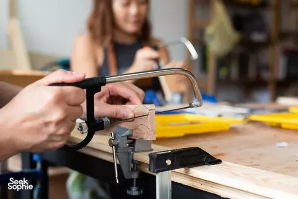 Tool and clamped wooden board on a workbench as participants work at a Singapore woodworking jewellery workshop — workshops in Singapore