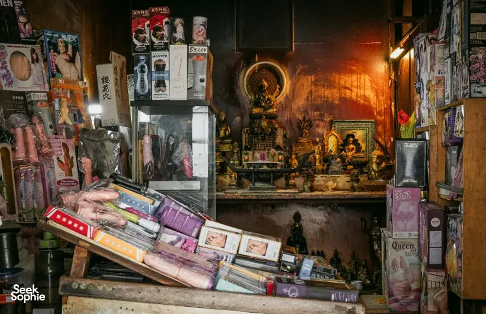 Interior toko yang sempit dipenuhi barang dalam kotak di kedua sisi, dengan altar di tengah, ditampilkan dalam Secrets of the Streets oleh Hidden Heritage tentang hidden gems di Singapura