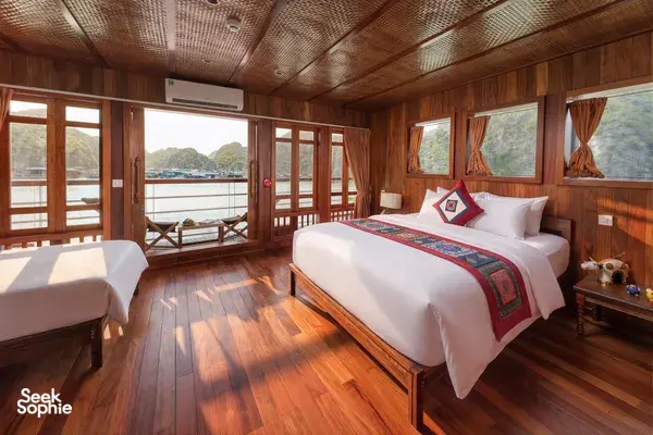 Cat Ba Ocean Cruises wooden cabin on a Cat Ba Boutique Cruise, with twin beds and sea views through large windows
