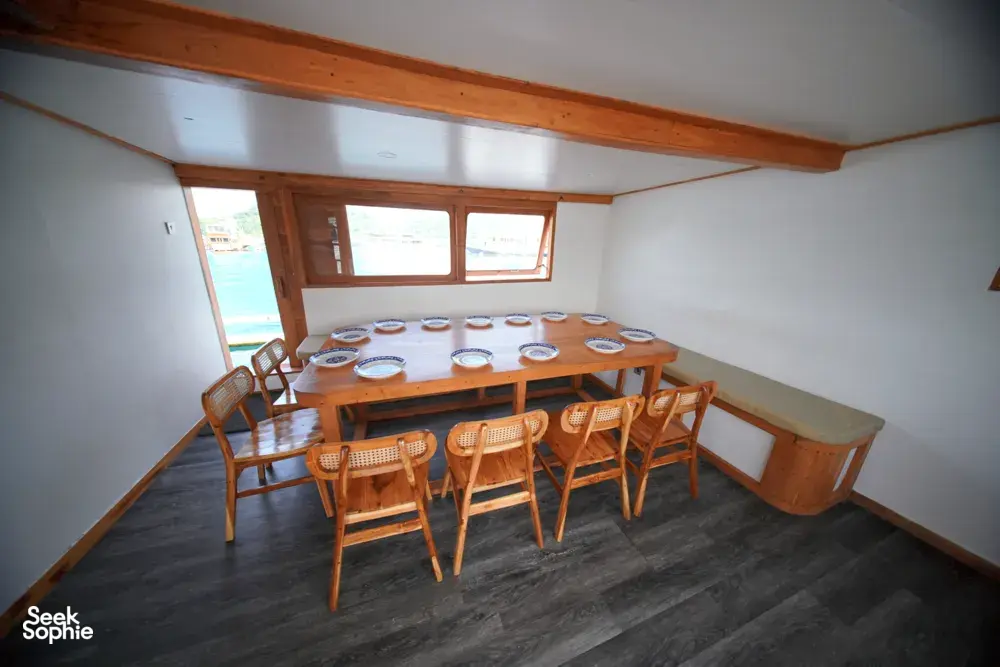 Dining area on a boat with a set table and chairs for a join-in 3D2N Komodo trip, near Komodo Island