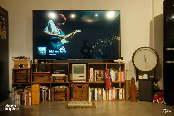 Cozy living room with bookshelves, decor and a TV screen in Primateve’s Singapore home, welcoming guests for private dining Singapore
