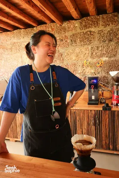 Family-run Yunnan coffee tasting in Lijiang: person in apron pours freshly brewed coffee on a wooden counter