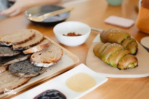 Sliced bread and small stuffed rolls on wooden boards during shio pan and flavoured butter hands-on workshops in Singapore