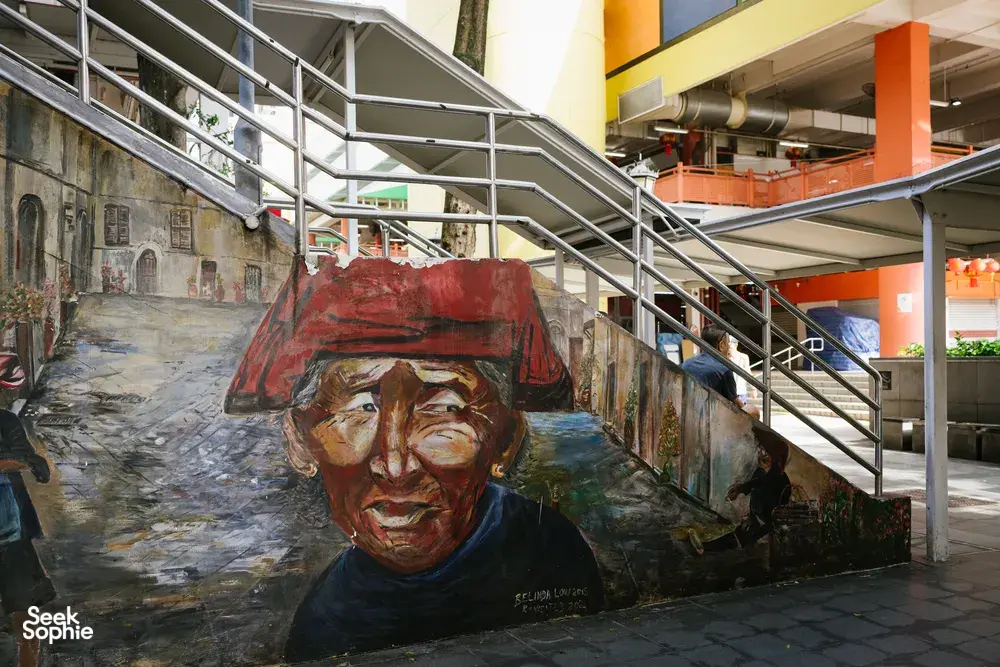 Street mural in Singapore Chinatown alley under a covered walkway, featuring a painted portrait as your team explores Singapore hidden gems