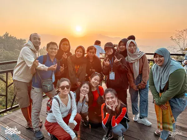 A group posing at golden hour on a scenic deck during a 10-hr private car and driver hire in Yogyakarta