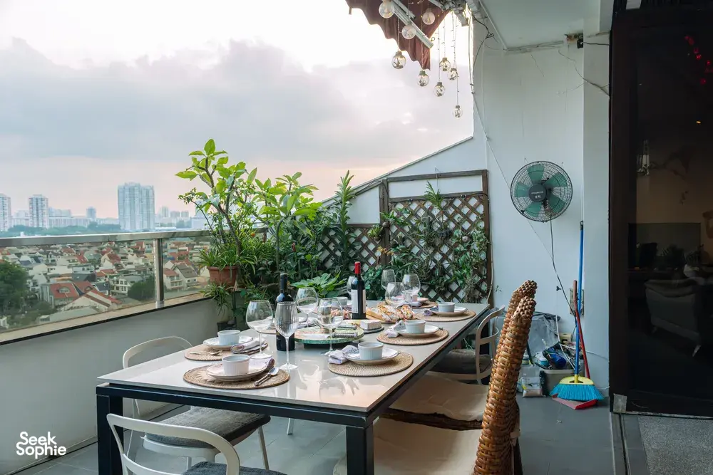 Cosy loft balcony dining table with glasses and wine, overlooking Singapore skyline—ideal for private dining Singapore