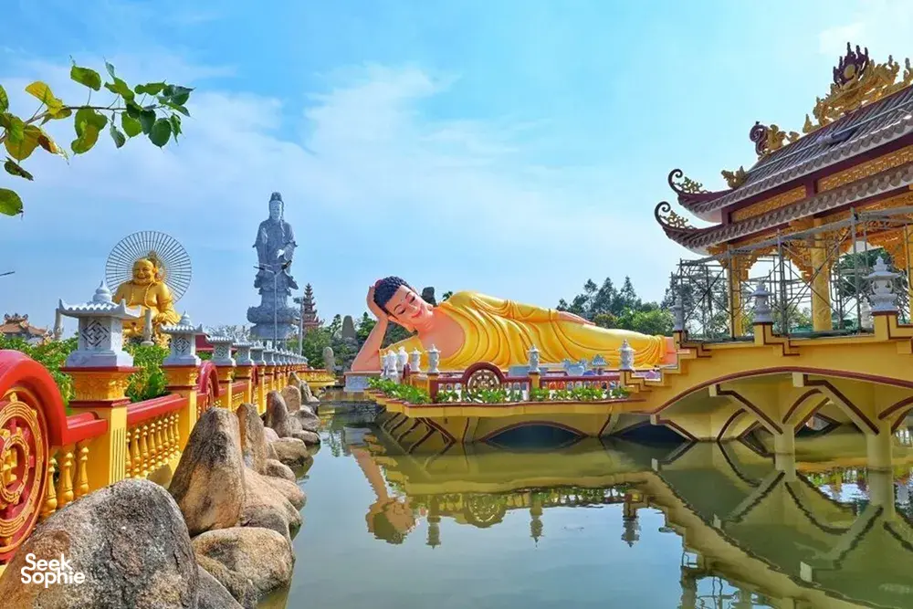 Colourful Mekong pagoda with Buddha statues and a reflecting pool during a Ho Chi Minh City to Mekong private transfer