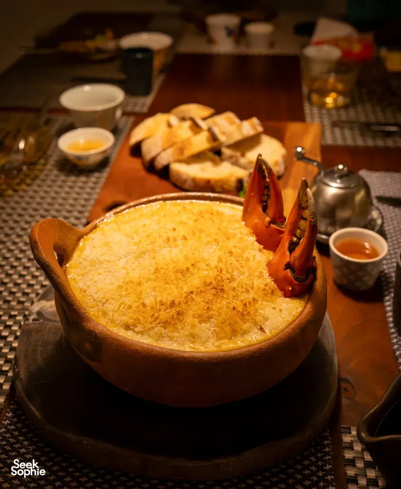 Golden crusted bowl with lobster tails and bread on a communal table at Primateve, private dining Singapore dinner