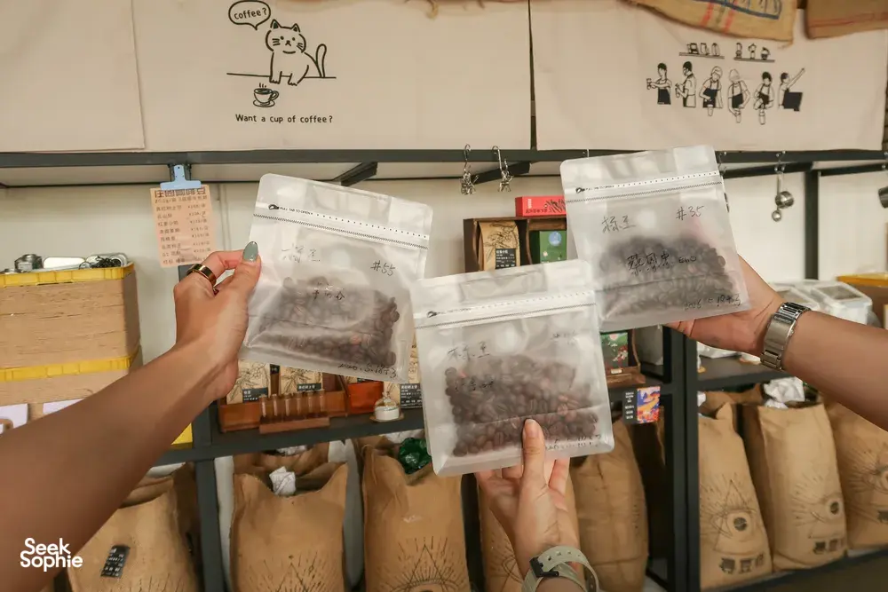 Coffee tasting supplies on wooden shelves, with hands holding sealed coffee sample bags at a family-run workshop in Lijiang