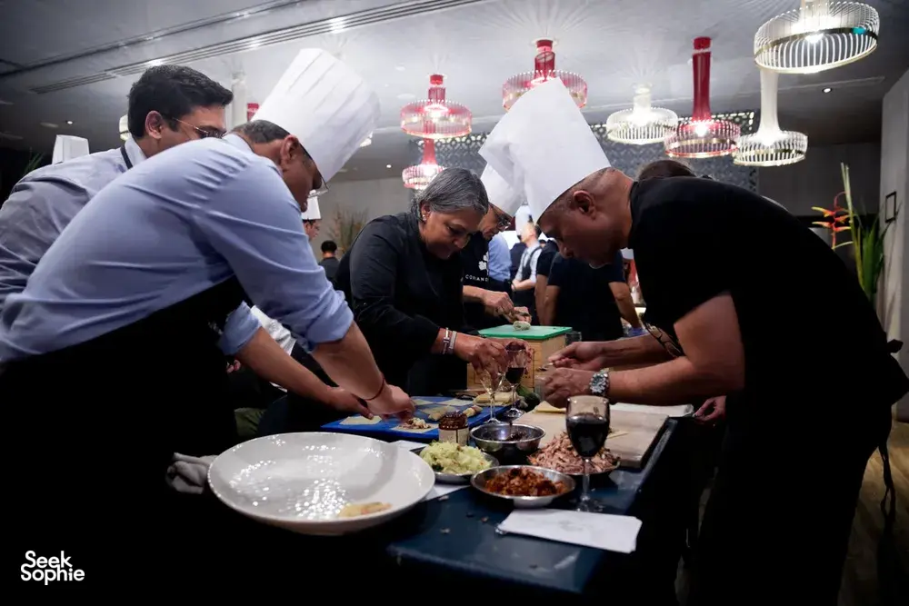 Teams plate dishes in Singapore during the local produce cooking challenge, chefs supervise at long tables — workshops in Singapore