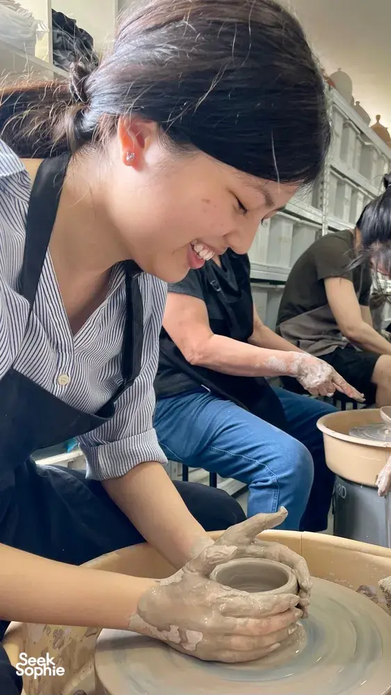 Woman shaping clay on a pottery wheel in Singapore at Joo Chiat Place, participating in the potter’s wheel lesson — workshops in Singapore
