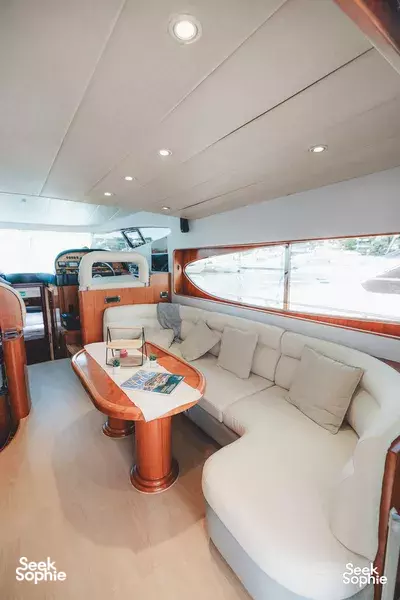 Inside a luxury yacht in Singapore, beige lounge seating beside a window for an Island Yacht Southern Islands cruise