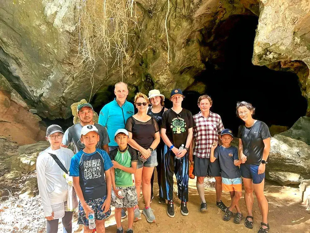 Group posing at the cave entrance of Kubang Badak caves in Langkawi during a guided eco tour exploring mangroves