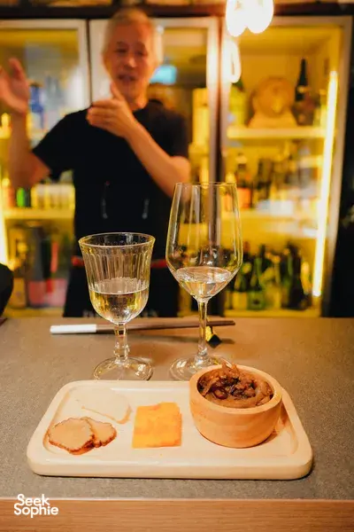 Sake tasting in a tucked-away Singapore shop with host SakeMama explaining pours over small plates, Singapore hidden gems