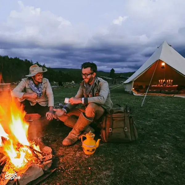 Campfire dinner at a canvas campsite in Shangri-La’s remote valleys, with travellers cooking beside a lantern-lit tent