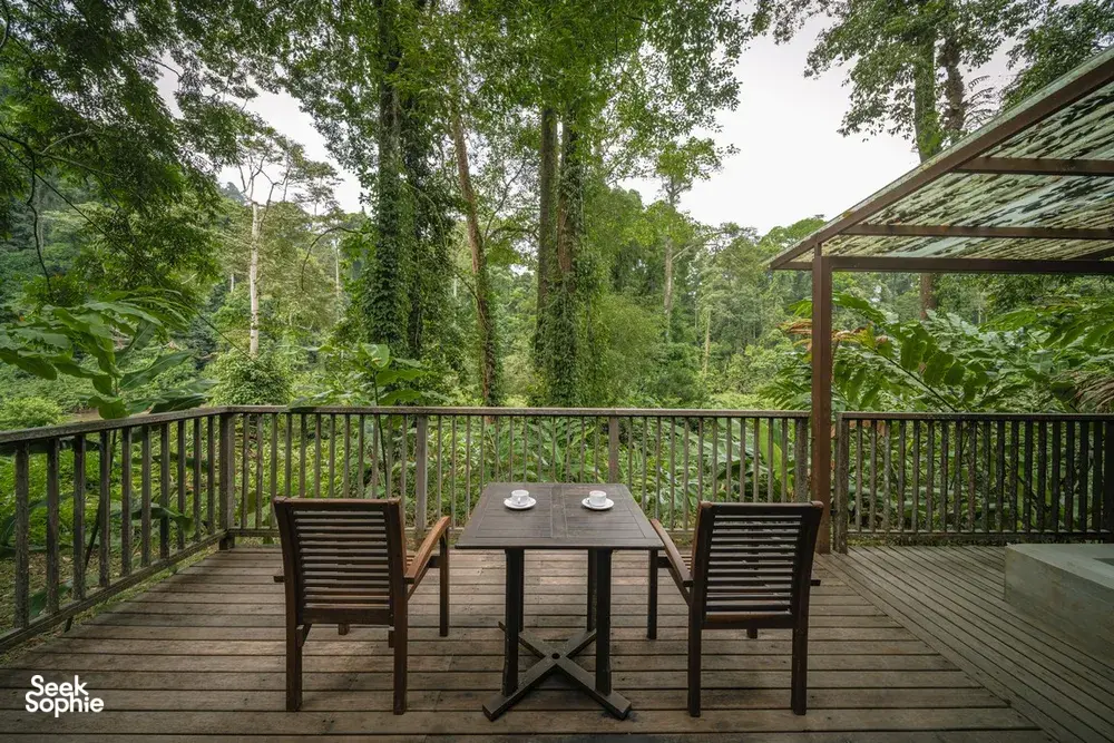 Outdoor deck at Borneo Rainforest Lodge in Danum Valley, with a dining table and chairs overlooking the rainforest