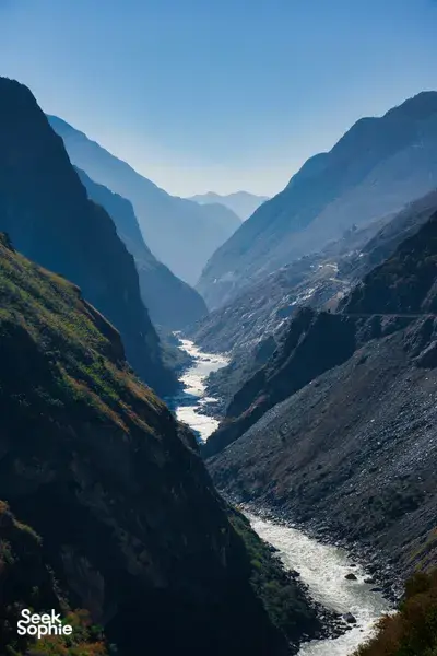 Winding river through deep mountain valleys in Shangri-La, viewed from a hiking trail overlook at blue hour