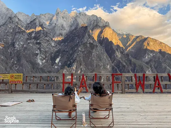 Travellers seated at a mountain viewpoint over steep peaks on the 2D1N Lesser-Known High Trail of Tiger Leaping Gorge, Lijiang