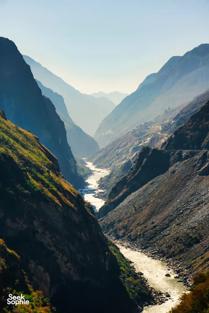 Ngarai sungai yang sempit di utara Yunnan, diapit gunung-ganang yang curam, dengan cahaya lembut menyinari lembah yang berliku