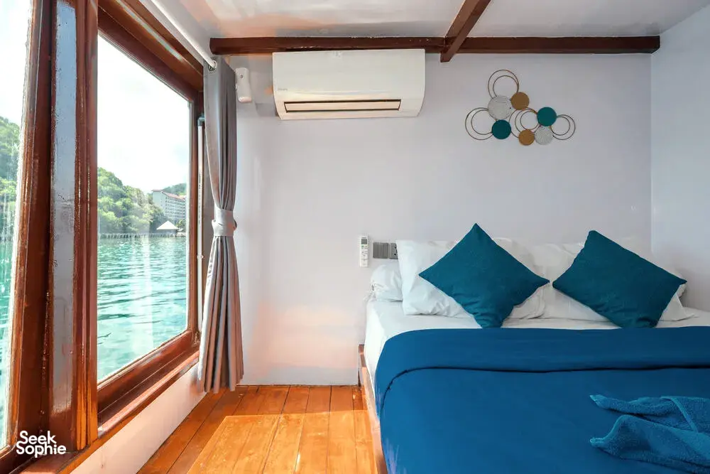 Onboard cabin on a phinisi with a window framing calm water during a private 3D2N Komodo cruise, near Labuan Bajo