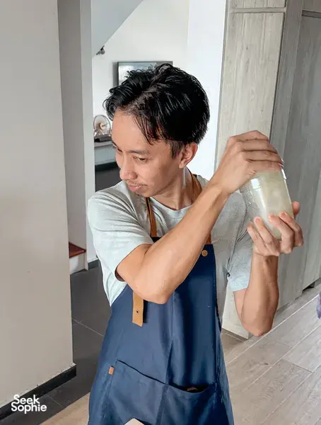The TCM Chef in Singapore pours and tastes a drink while preparing TCM herbal mocktails for a food-as-medicine class