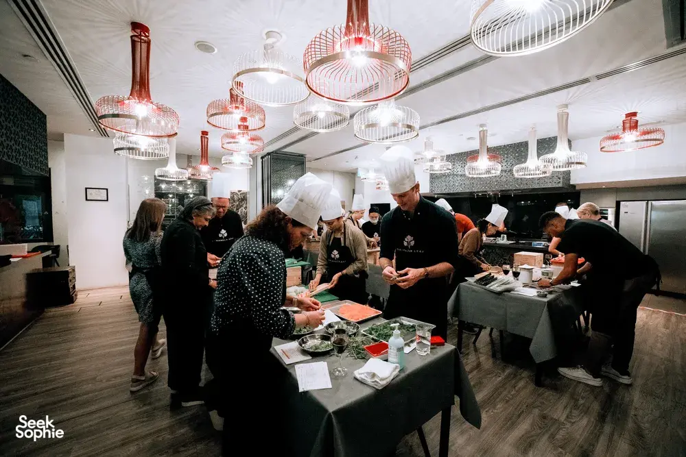 Local produce cooking challenge for teams in Singapore, chefs guide groups cooking at shared stations — workshops in Singapore
