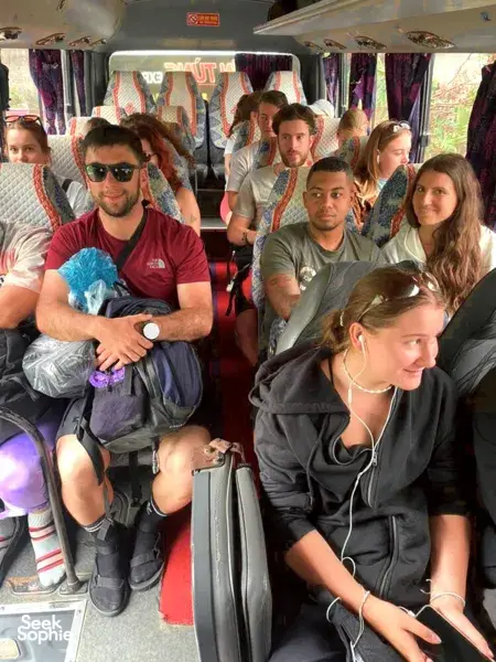Close-up of travellers relaxing inside a Son Tung Express bus on the Cat Ba to Halong Bay transfer, seat rows ahead