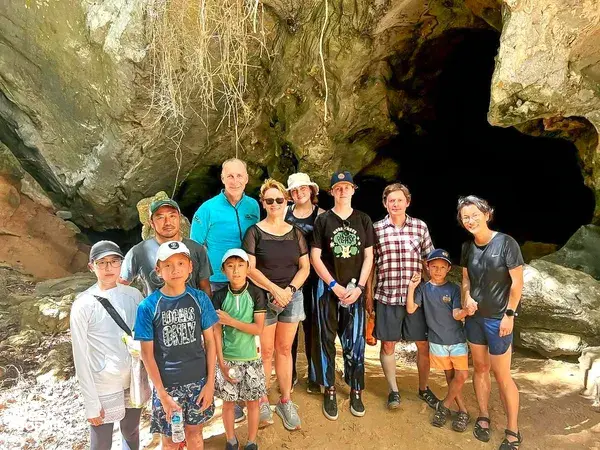 Group posing at the cave entrance of Kubang Badak caves in Langkawi during a guided eco tour exploring mangroves