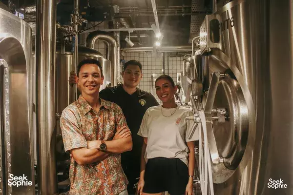 Lion Brewery Co Brewpub Tour in Singapore: small group standing in a brewery room among large stainless-steel brewing tanks