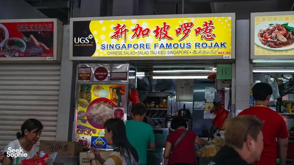Singapore hawker stall frontage with a large rojak sign above the kitchen counter and customers queuing inside — Singapore hidden gems