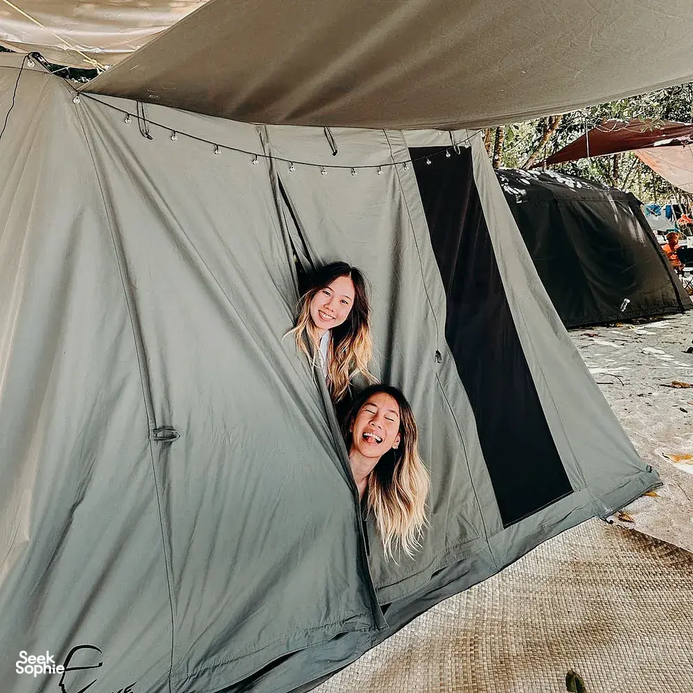 Travellers smiling inside a canvas beach camping tent at Surin Island, Khao Lak’s shoreline during camping stay