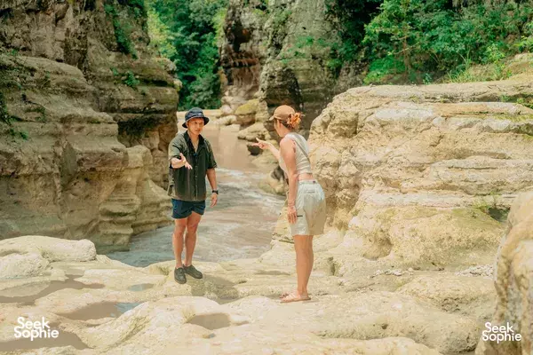 Local driver chatting with travellers at a rocky gorge in Sumba during a private car & driver day