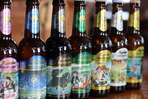 Rows of bottled beer with colourful labels at a Tibetan brewery in Shangri-La, ready for visitors to sample