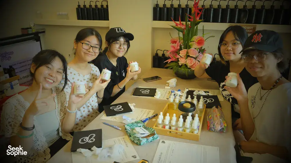 Smiling group at Perfume Play’s workshops in Singapore, making scented coco-soy candles with fragrance tools on a shared table