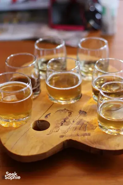 Selection of small glasses of amber tea on a wooden board for a Tibetan tea tasting ceremony in Shangri-La