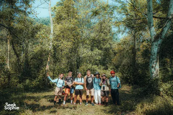 Group of trekkers posing on a forest path in Phong Nha, Quảng Bình, preparing for a 2D1N hike featuring ancient caves