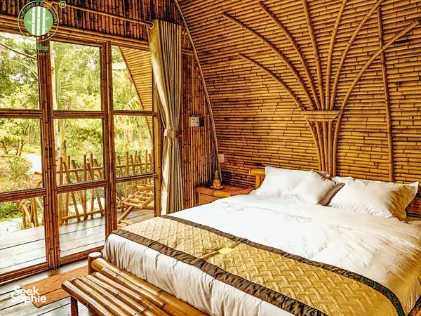 Bamboo bedroom inside Bamboo Eco Village luxury eco homestay in Cần Thơ, with a double bed and bright garden views