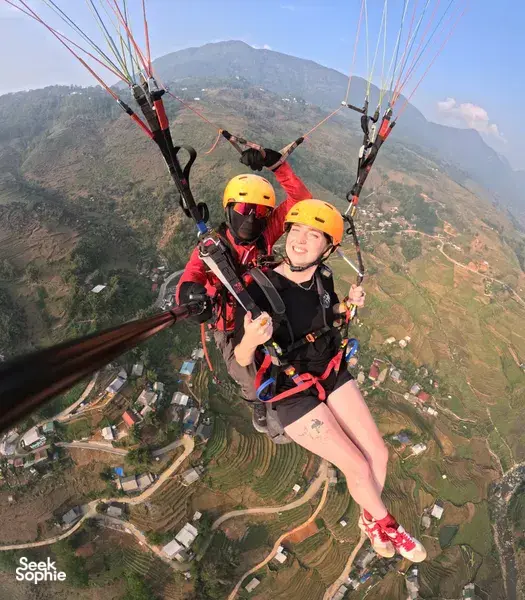Tandem paragliding flight with Sapa Paragliding over Vietnam’s terraced valleys beneath the wing from above, Sapa