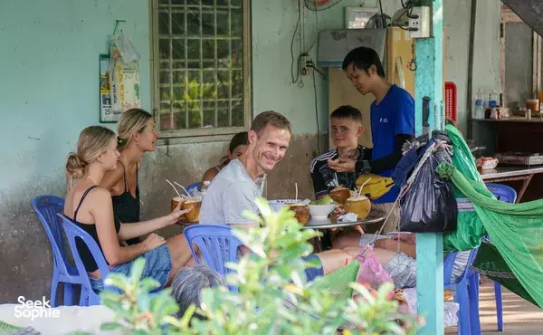 Bike tour group sharing Vietnamese food at a local restaurant on Mekong Island near Ho Chi Minh City, Jackfruit Adventure
