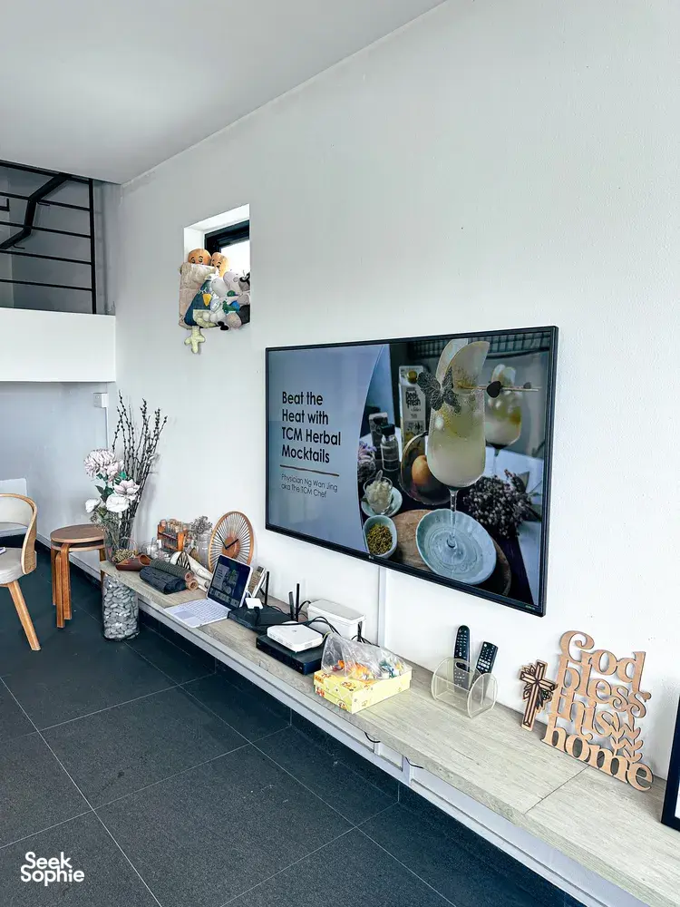Singapore TCM mocktails studio counter with bottles and a framed poster about beating the heat with herbal mocktails
