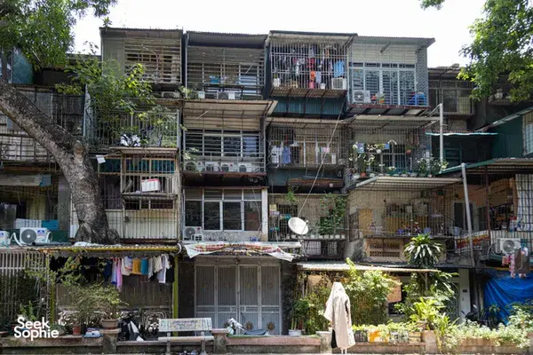 Weathered multi-storey apartment blocks with metal-framed balconies and laundry lines in a Hanoi collective housing neighbourhood