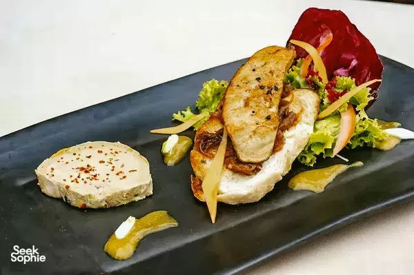 Plated appetiser at The Island Lodge in the Mekong Delta, with grilled meat slices, crisp salad greens and garnish on slate