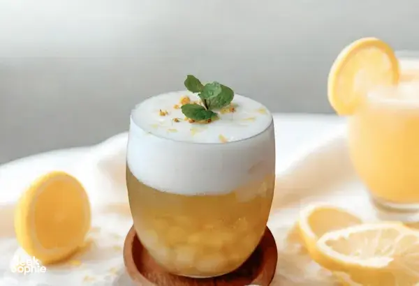 Layered TCM mocktail in a tall glass with mint and lemon slices on a table during food-as-medicine workshops in Singapore