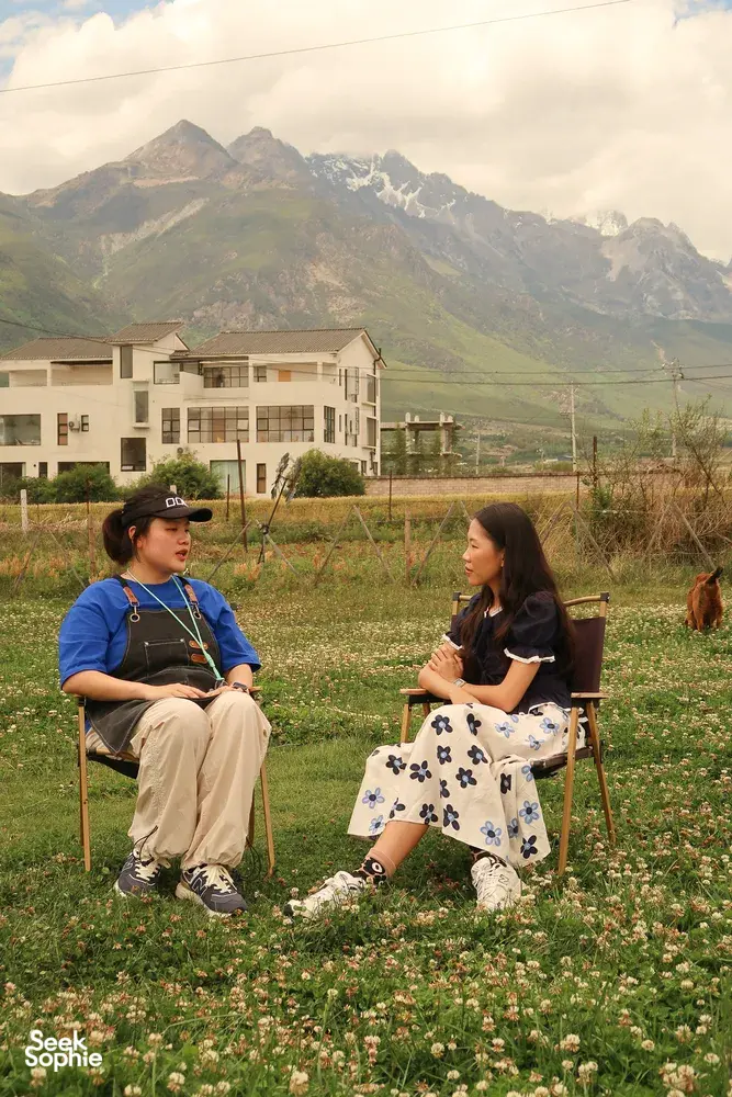Family-run coffee workshop in Lijiang: Seeker Yunnan Coffee Estate host chatting with a guest among blooming fields and peaks