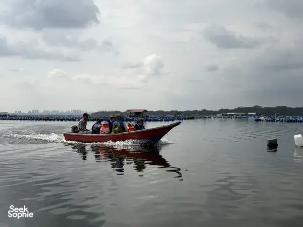 Red motorboat carrying passengers through Johor Bahru’s calm coastal waters, part of a private Explore Orang Seletar heritage tour