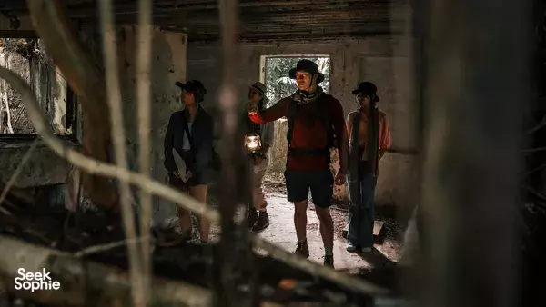 Expedition members walking through a torch-lit passageway at Fort Serapong, Singapore, on a time-travel discovery trail