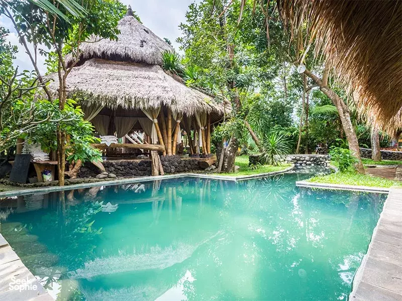 Thatched-roof cottages beside a calm garden pool at Omunity Bali in Bali for a 3D2N sacred meditation stay